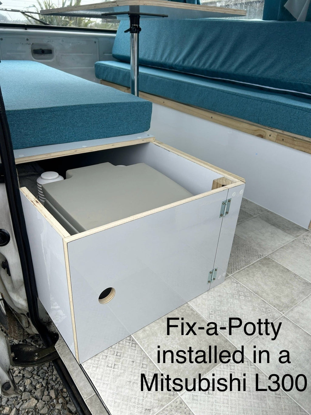 Portable toilet bracket installed inside a campervan